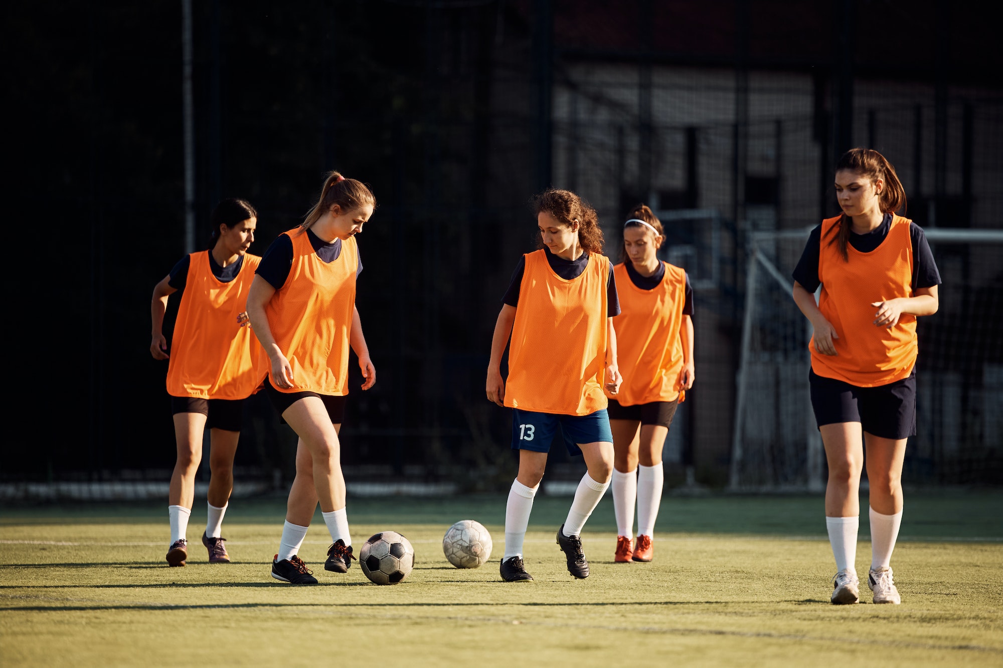 Female soccer players having sports training at the stadium.