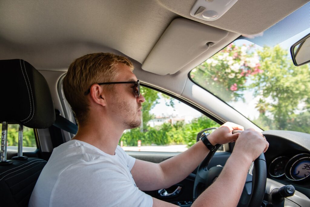 Man in sunglasses driving a car