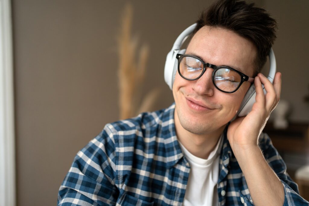 man with glasses listening to music with headphones
